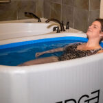 A woman lying in the Cold Plunge tub